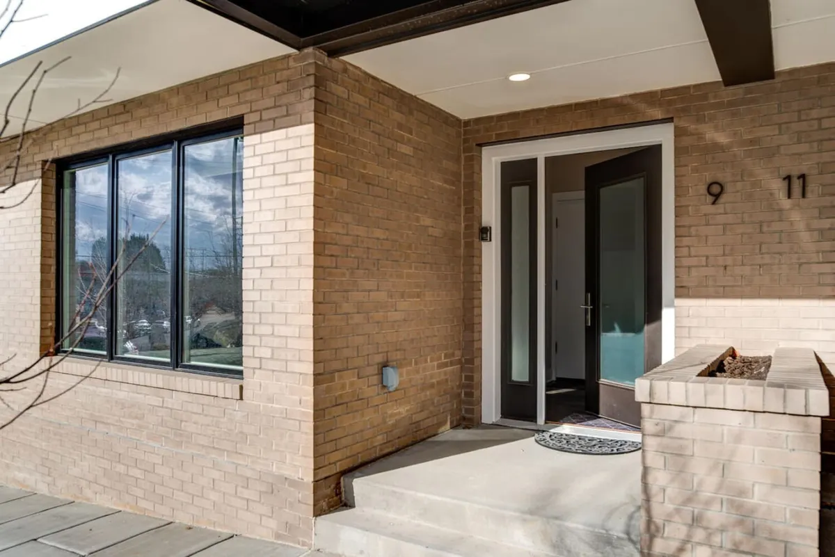This image captures the main entrance of the property, showcasing a welcoming entryway with a brick facade and large windows. The scene hints at both security and curb appeal, offering a first impression of the home.